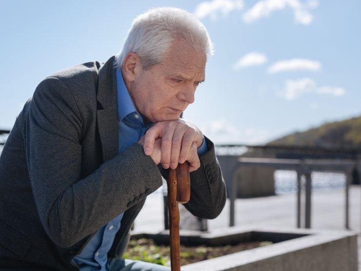 pensionato triste seduto su una panchina