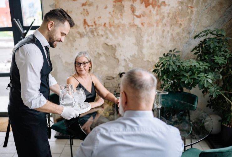 un cameriere che sparecchia ad un tavolo